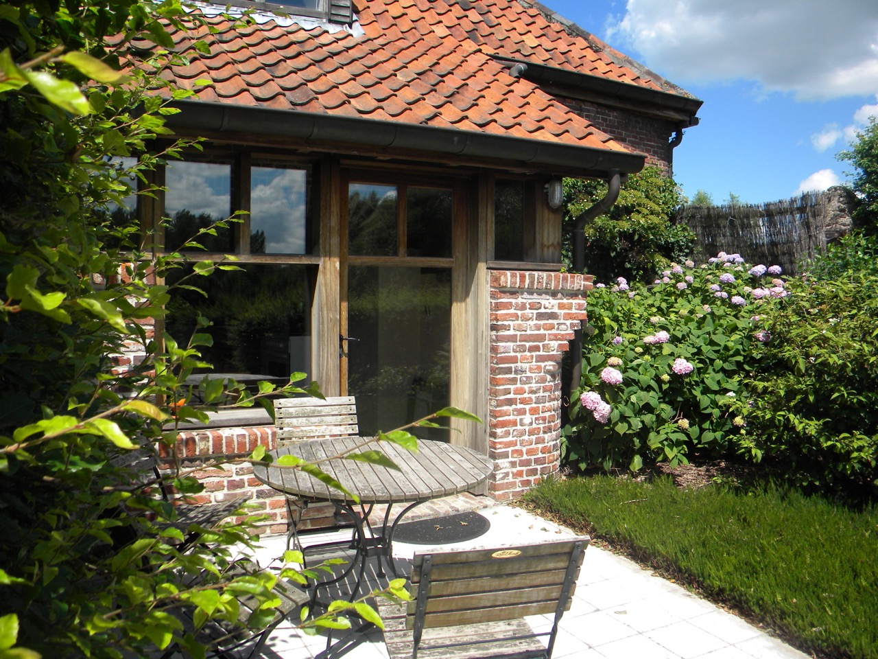 zicht op terras en achterdeur van onze vakantiewoning in de vlaamse ardennen